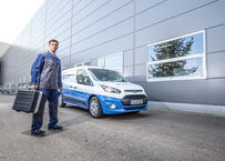 Blueserv employee with toolbox in front of branded Blueserv car